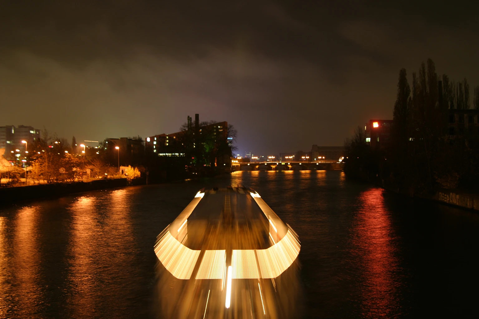 Langzeitbelichtung eines Schiffs bei Nacht mit Lichtspur - Sinnbild für Geschwindigkeit, echtes Foto von Johannes Lenkeit